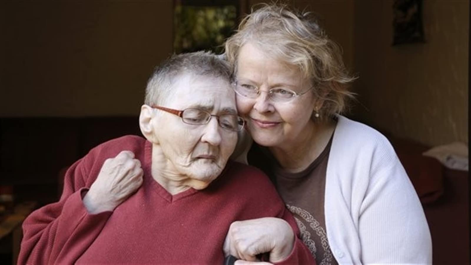 Une proche aidante donne du réconfort à une aînée malade.