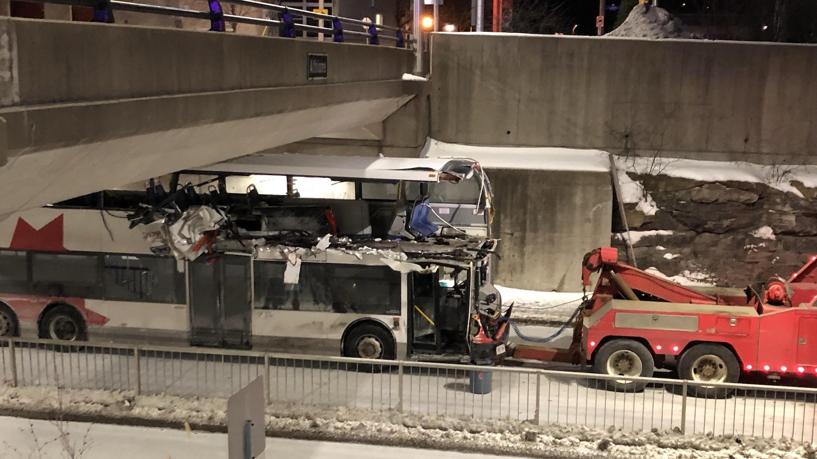 L'autobus accidenté se fait remorquer hors du lieu de l'accident.