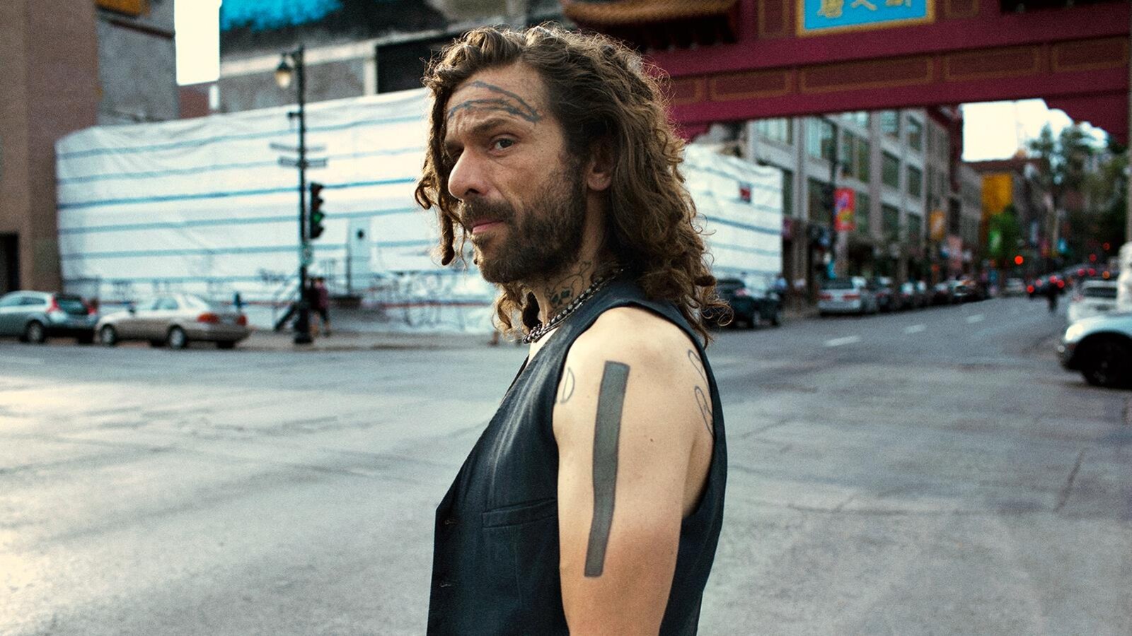 Un homme se tient dans la rue, à une intersection d'une artère principale de Montréal.
