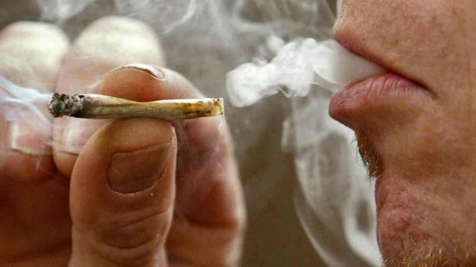 Un homme fume du cannabis.