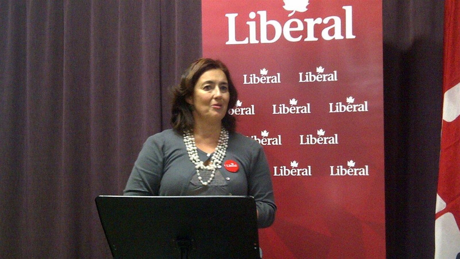 Une femme est sur une scène et livre un discours.
