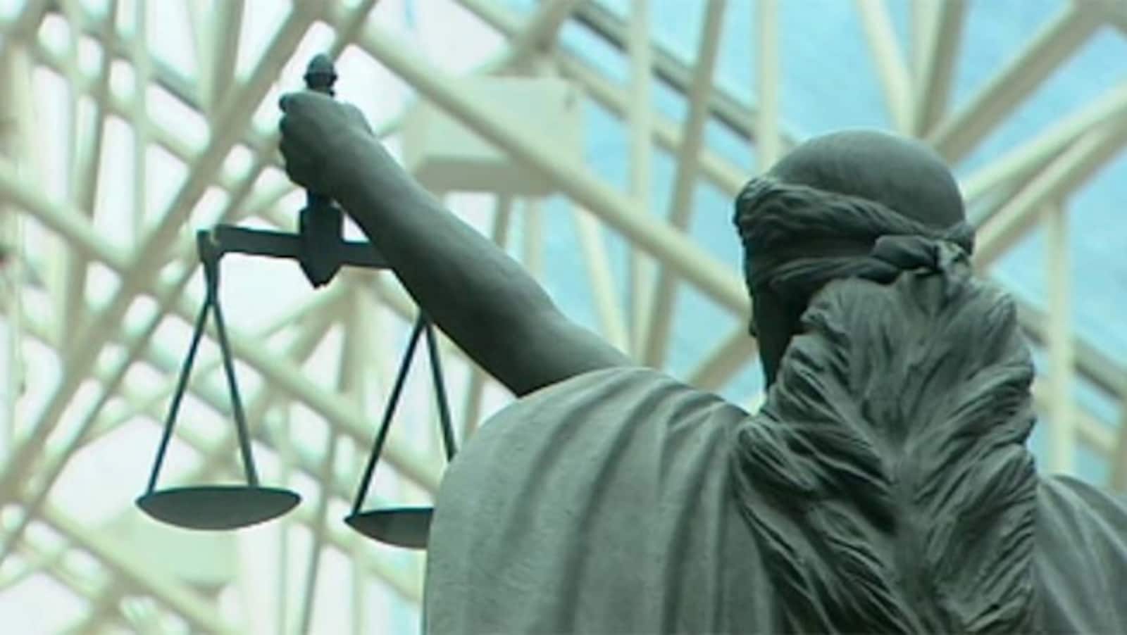 La statue d'une femme tenant une balance au bout de son bras.