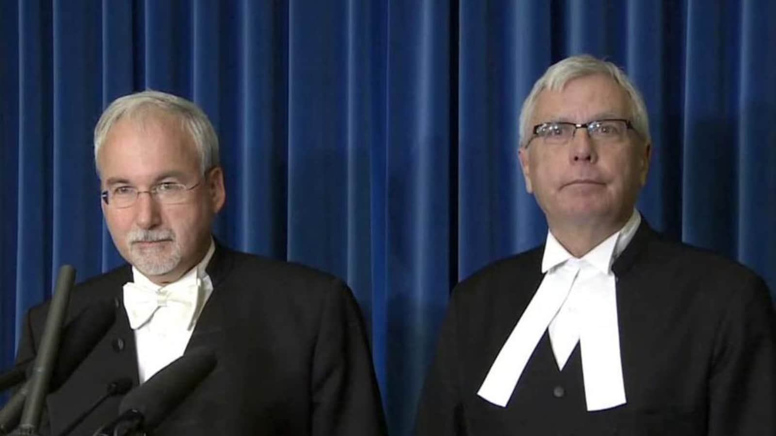 Deux hommes aux cheveux blancs assis côte à côte.