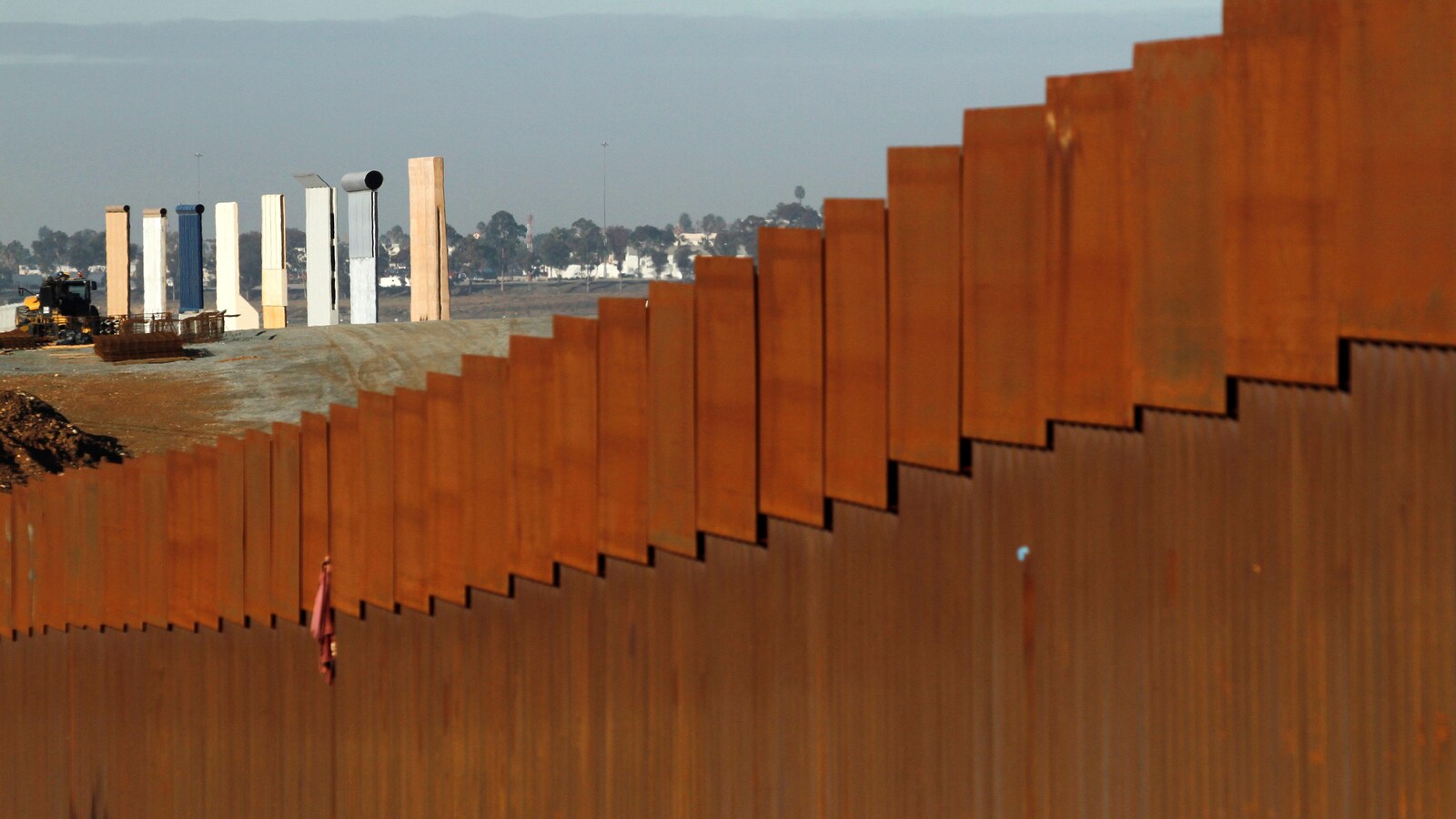 Les prototypes du mur frontalier du président américain Donald Trump sont visibles derrière la barrière entre le Mexique et les États-Unis, à Tijuana.