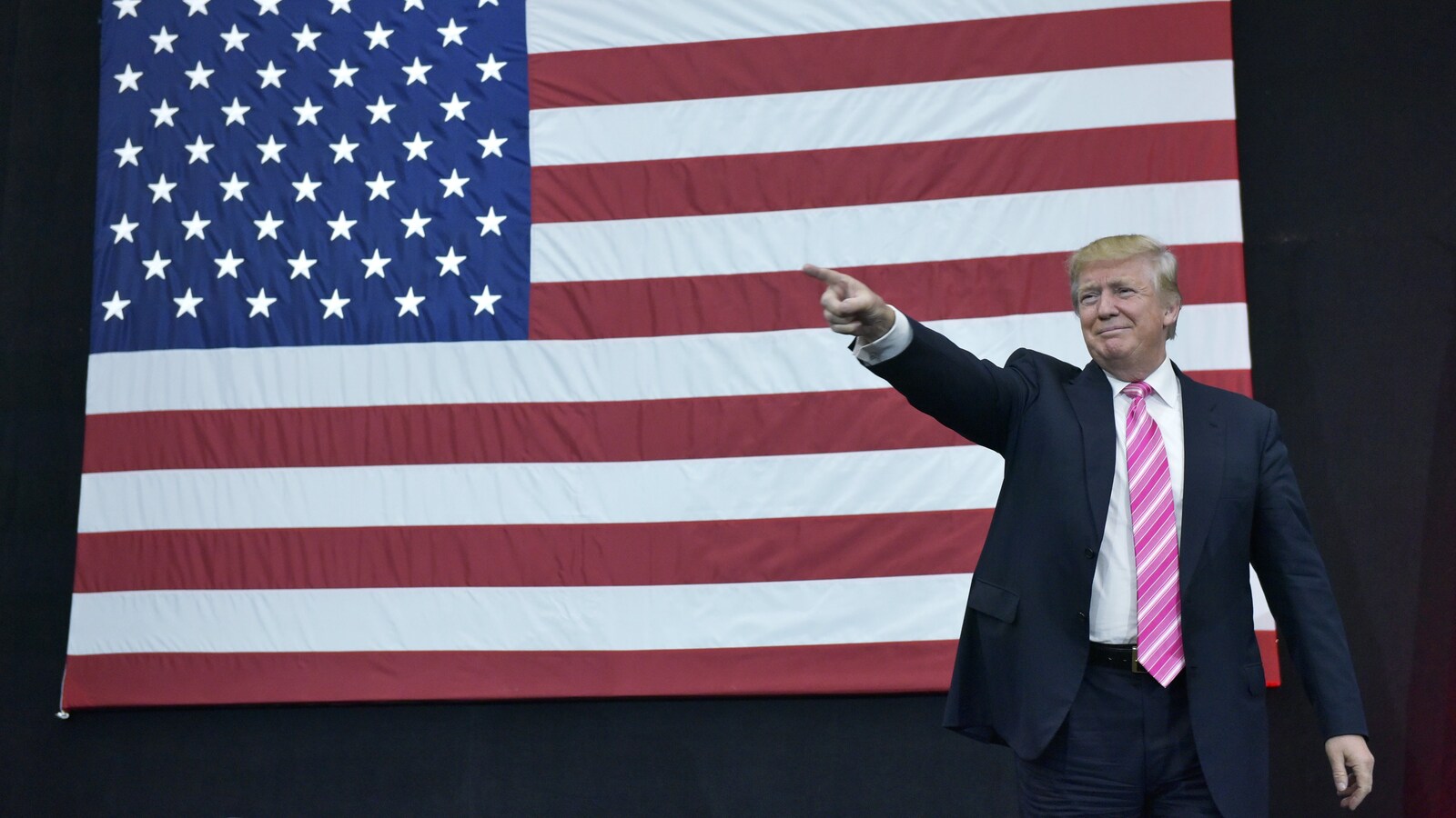 Le président Donald Trump devant un immense drapeau américain