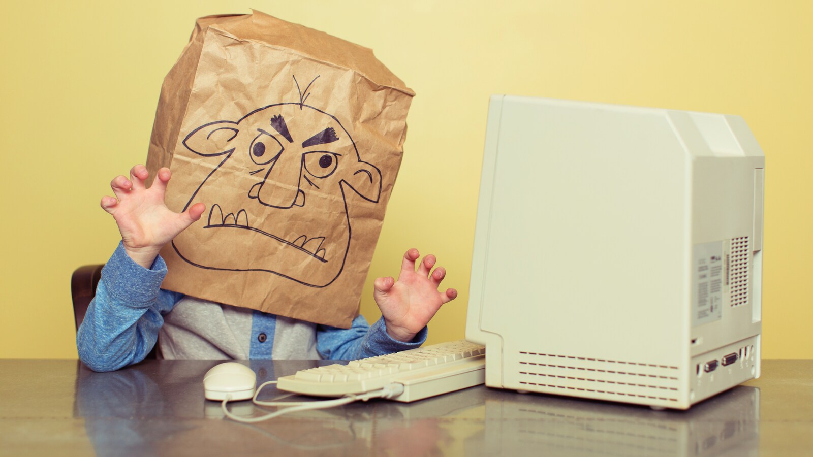 Un internaute se cache derrière son écran pour écrire des propos disgracieux à l'ère des réseaux sociaux.