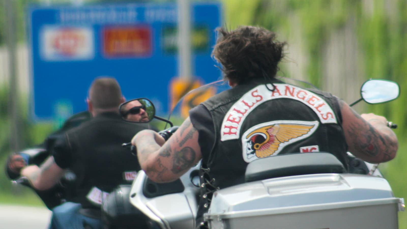 Deux motards des Hells Angels circulent sur une autoroute.