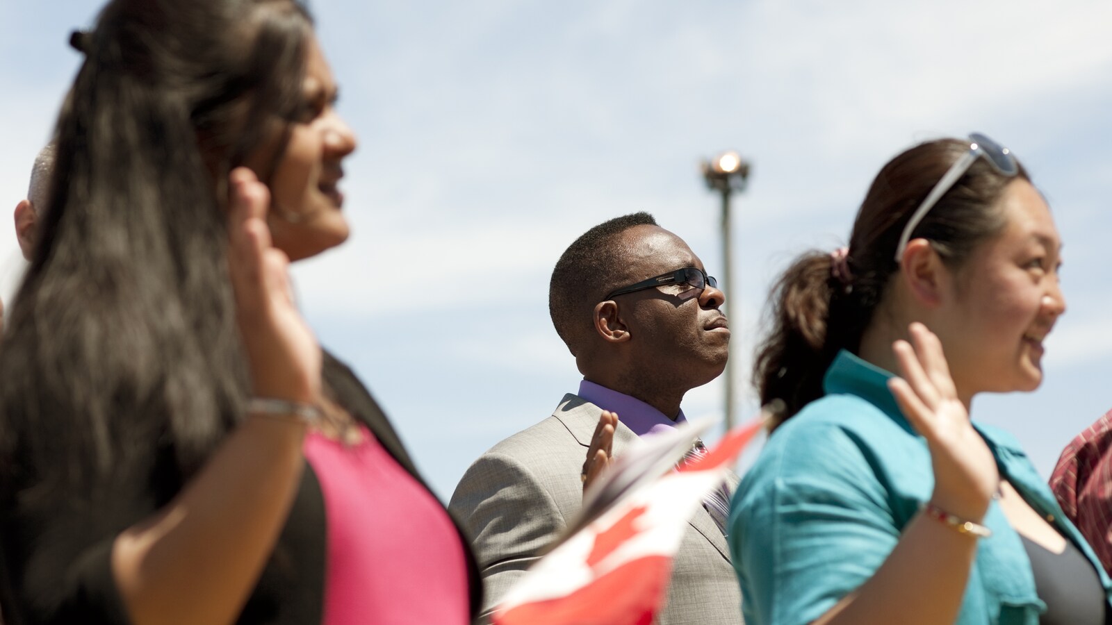 Des immigrants lors d'une assermentation pour l'obtention de la citoyenneté canadienne.