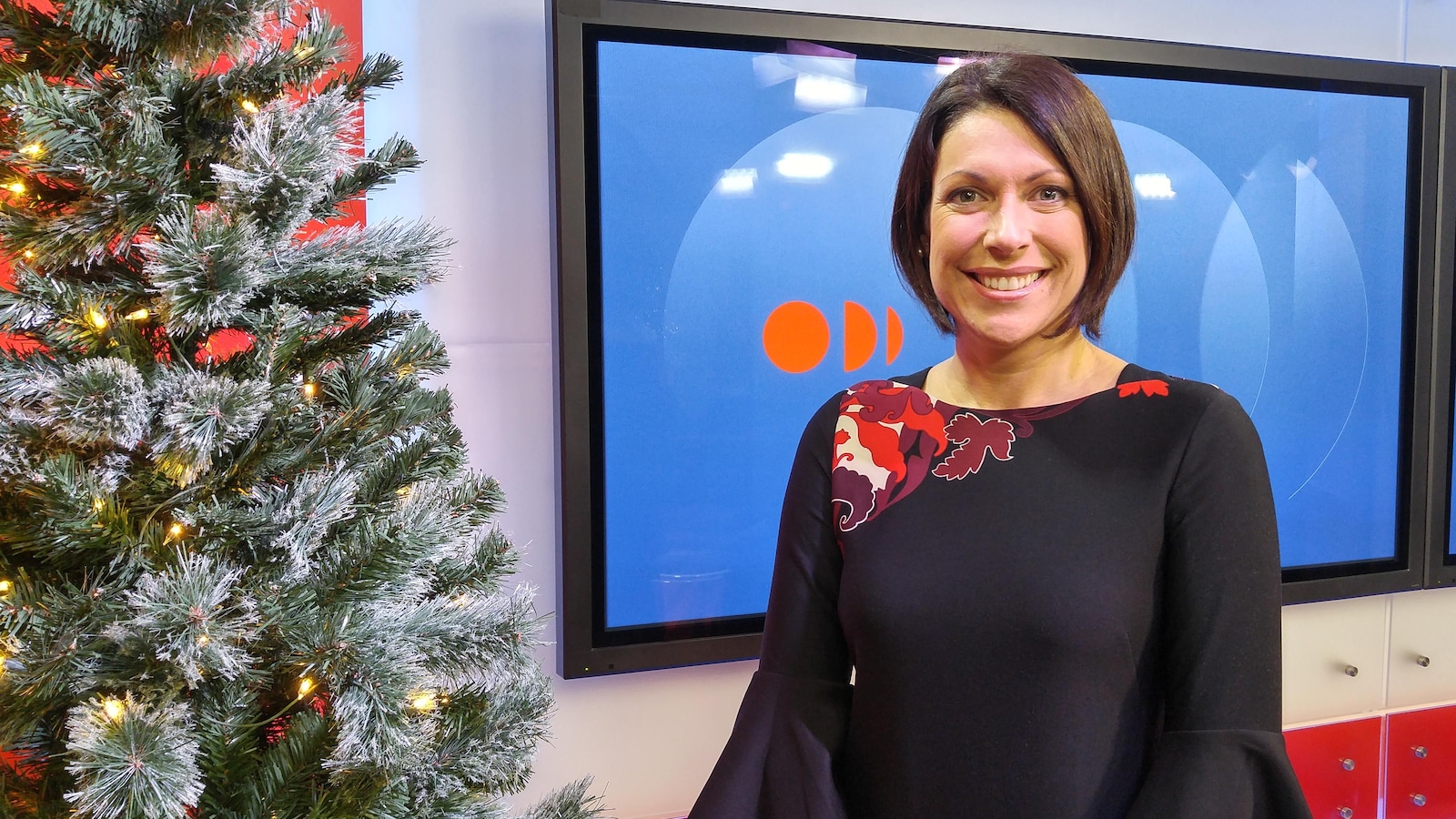 Karine Trudel pose à côté d'un sapin de Noël.