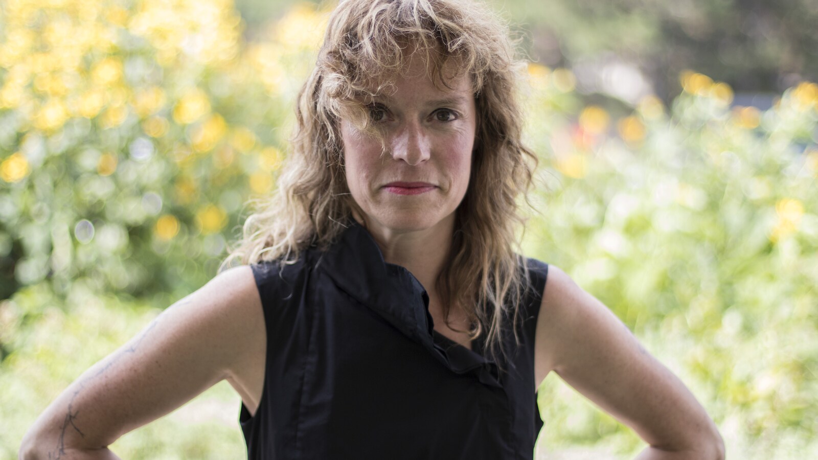 Elle sourit à la caméra.