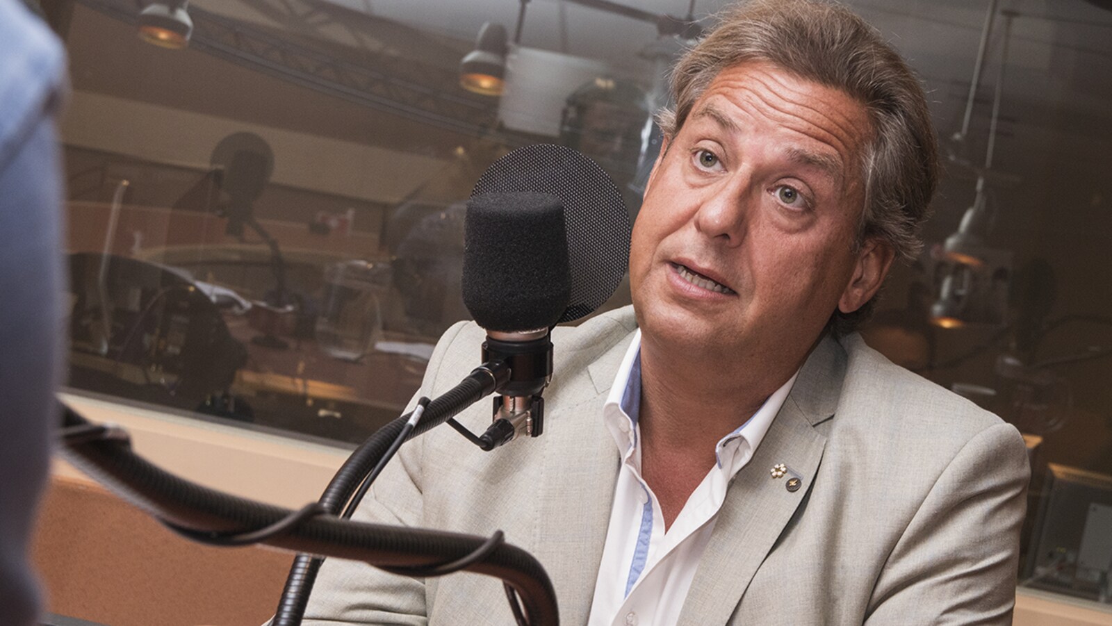 Alain Lefèvre devant un micro dans un studio de radio.