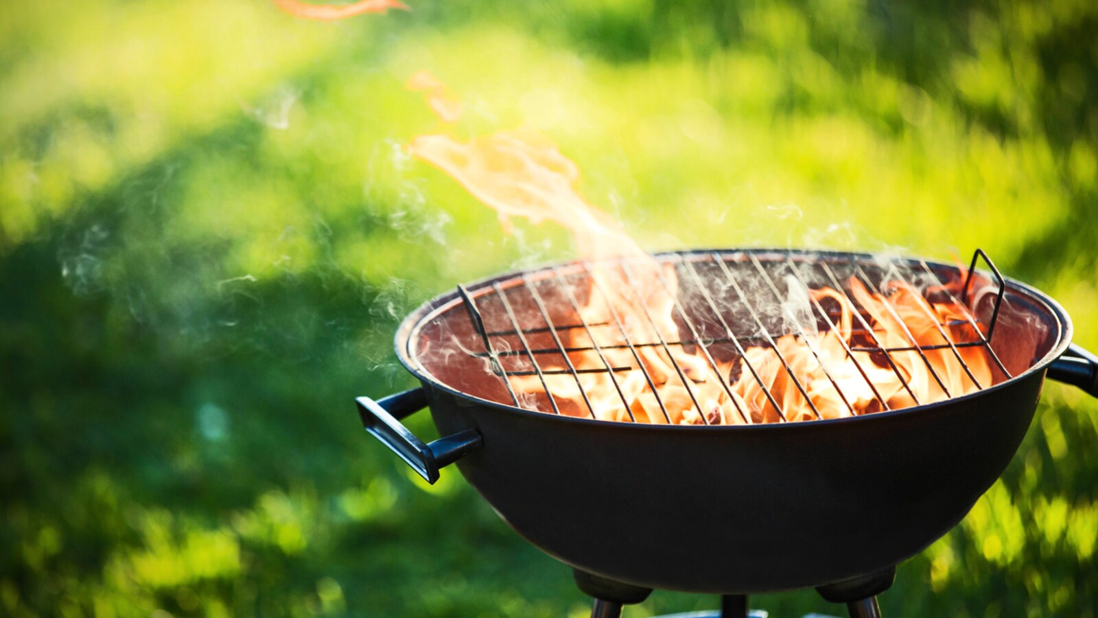 Un gril de barbecue dans lequel brûlent des flammes.