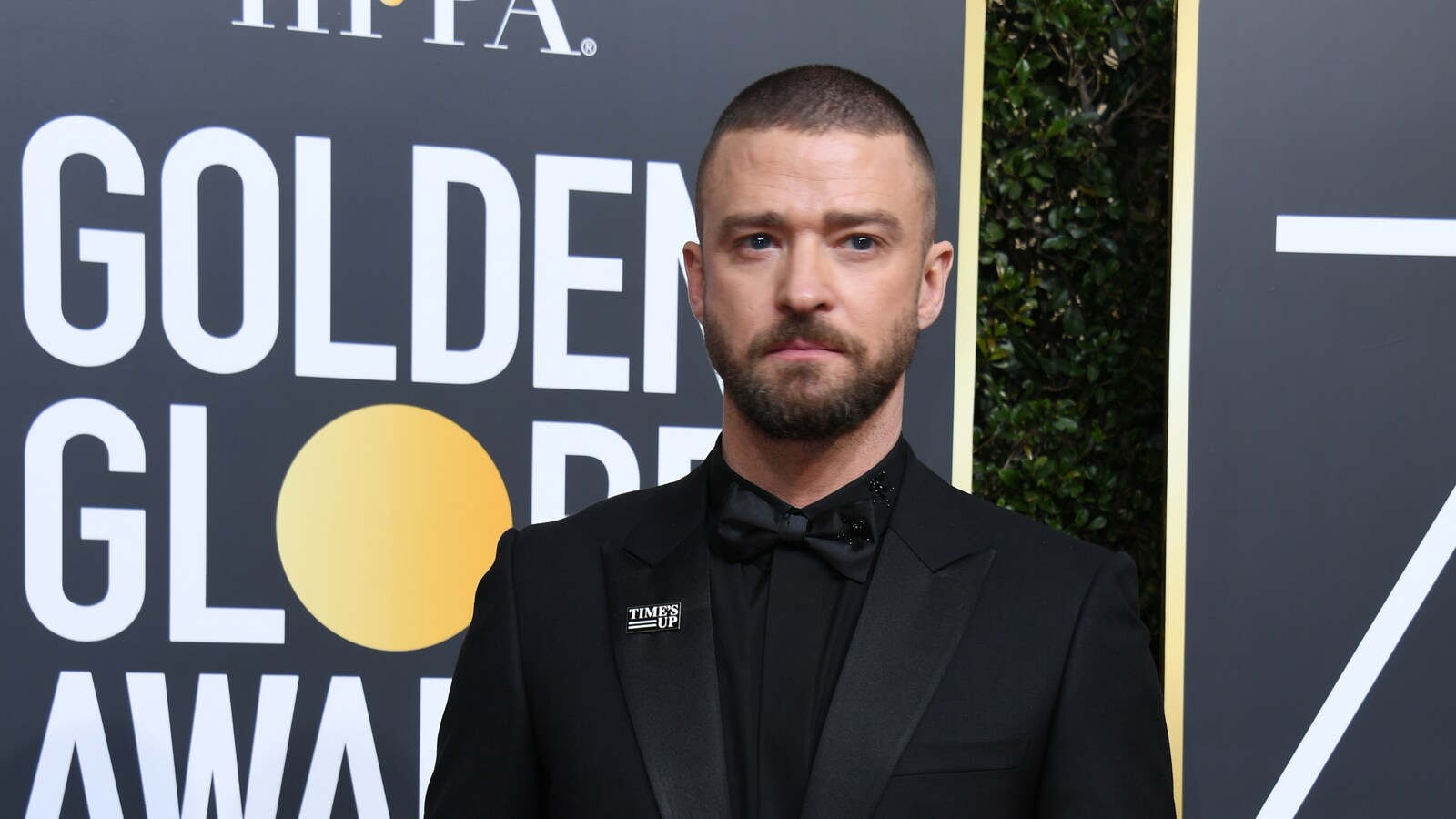 Justin Timberlake devant un panneau à l'effigie des prix Golden Globe
