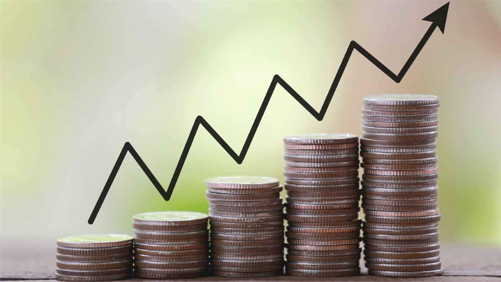 Des piles de pièces de monnaie en forme de graphique pour représenter le concept de croissance économique.