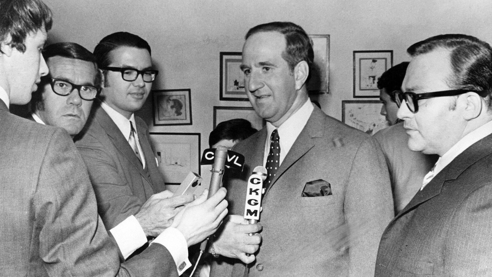 En 1970, le ministre du Travail du Québec Pierre Laporte est entouré de journalistes et de micros.