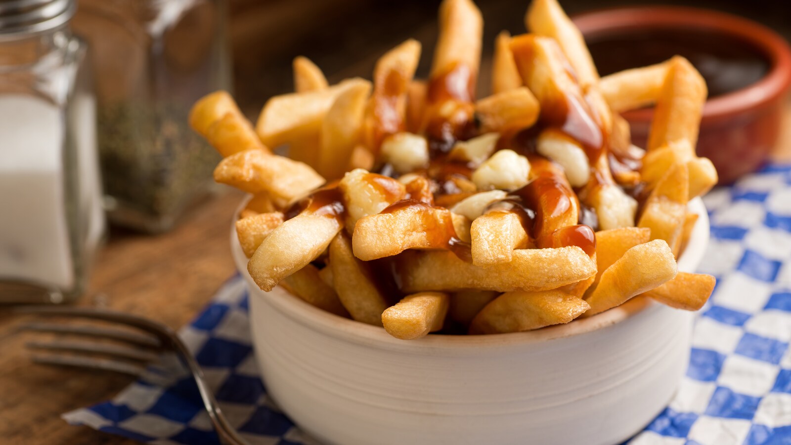 Une poutine dans un bol blanc avec une fourchette