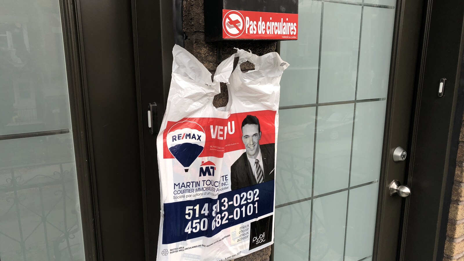 Un publisac accroché sous un autocollant qui dit « Pas de circulaires».