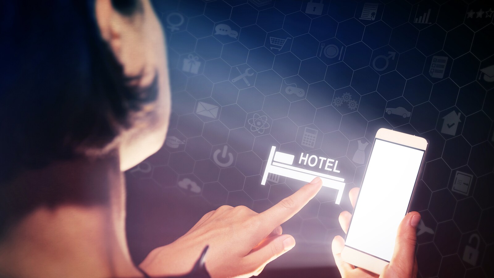 Une femme avec un téléphone intelligent dans sa main appuie sur une icône d'hôtel.