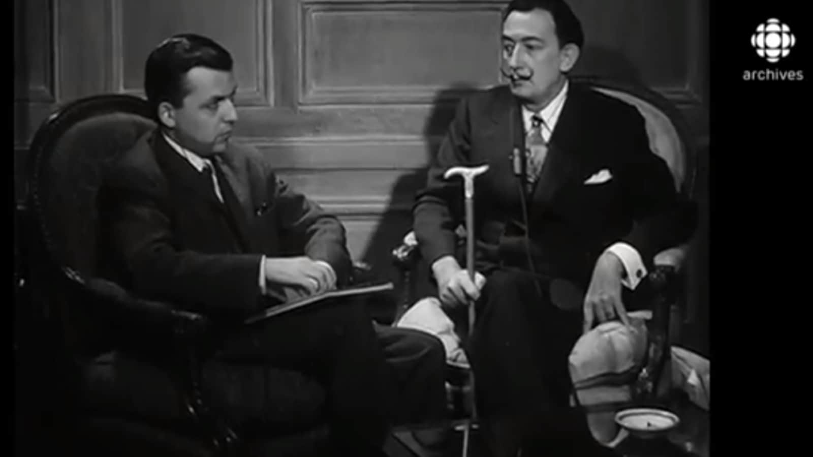 Salvador Dali, canne à la main, est assis en face de l'animateur Wilfrid Lemoine en mai 1958. 