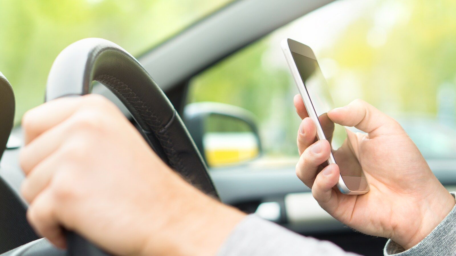 Un homme conduit tout en textant.