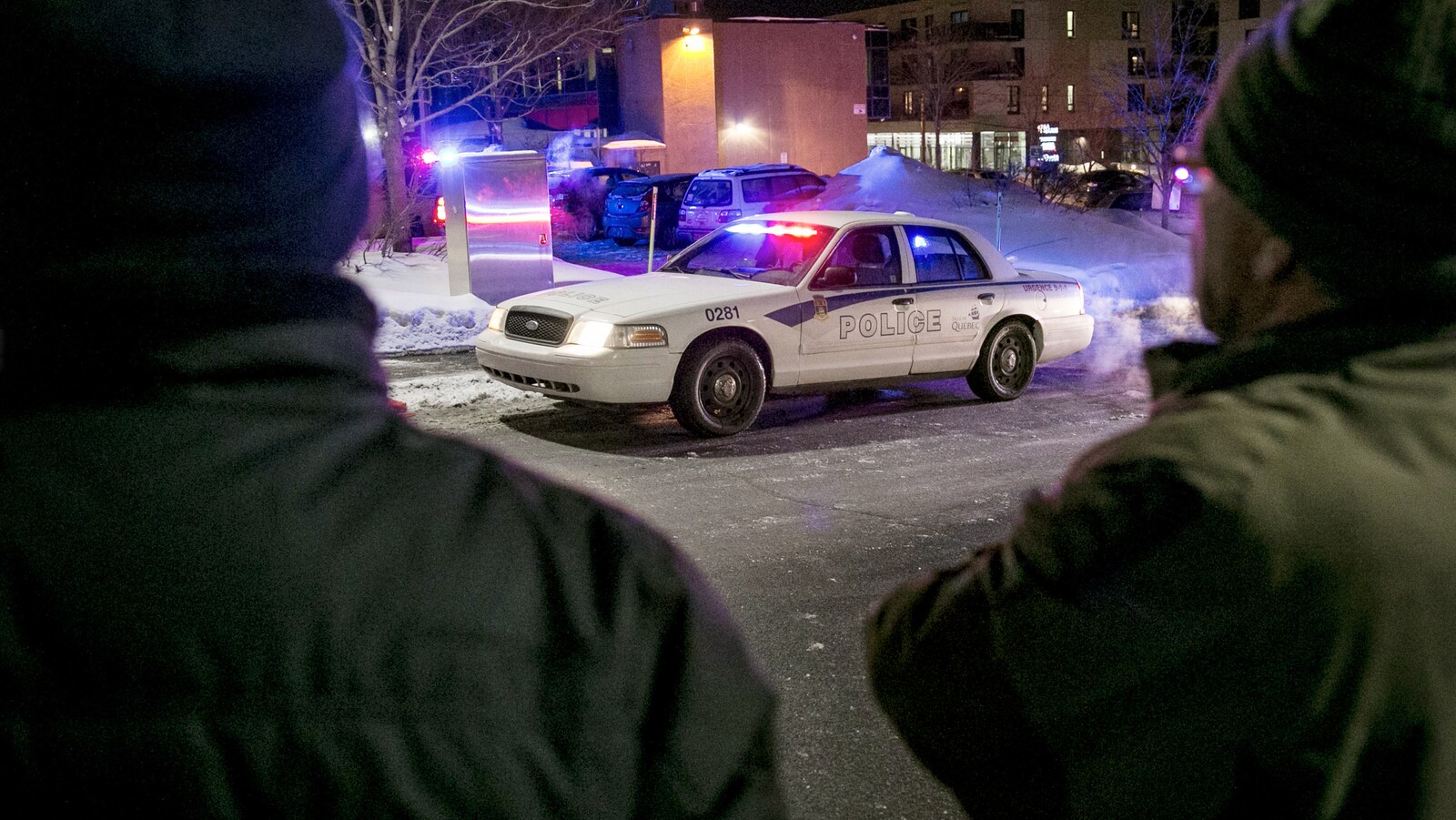 Deux hommes regardent la grande mosquée de Québec dans les instants après l’attentat.(archives)