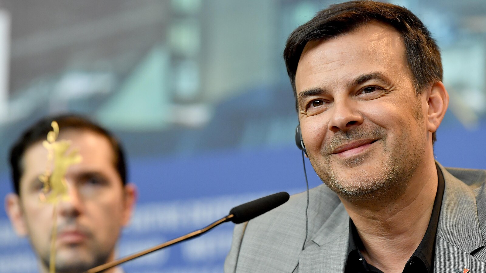 François Ozon est souriant.
