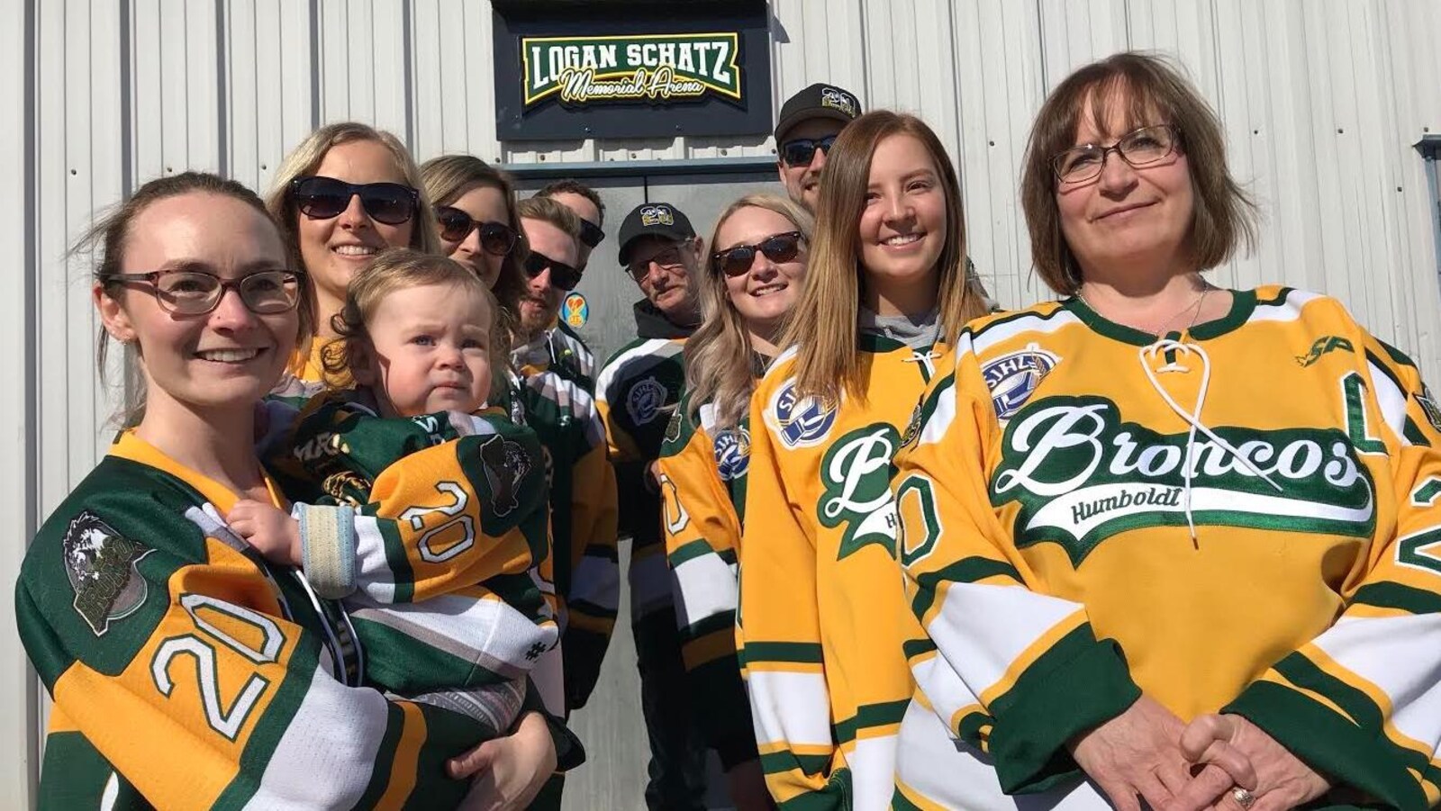 La famille de Logan Schatz pose devant le logo extérieur de l'aréna