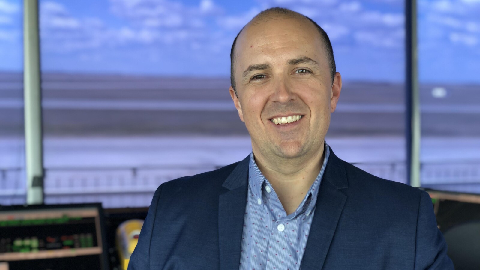 Marc Brisebois dans la tour avec la piste d'atterrissage derrière lui.