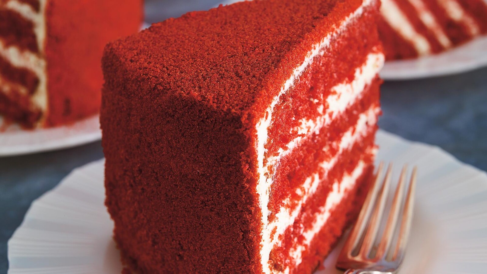 Des morceaux de gâteaux rouge et blanc dans des assiettes