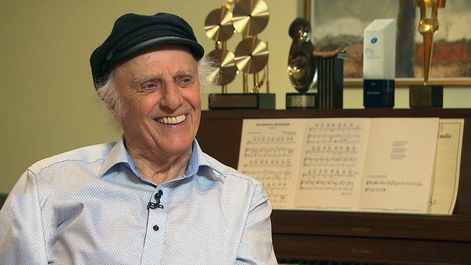 Gilles Vigneault en entrevue chez lui, en novembre 2017, à 89 ans. Il porte une casquette et est assis au piano.