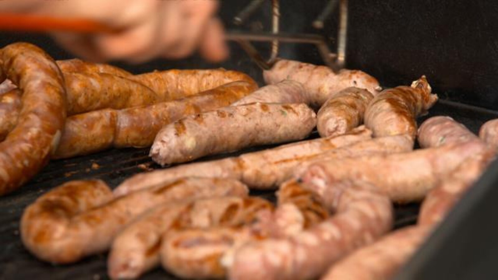 Les saucisses sont grillées sur le barbecue.