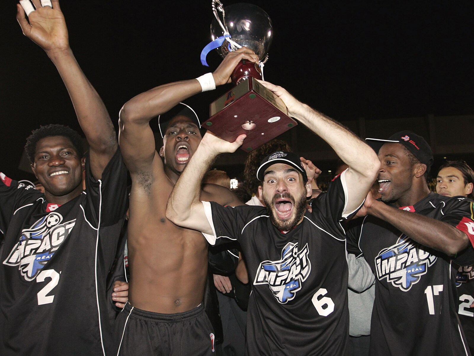 Deux joueurs de l’impact brandissent un trophée