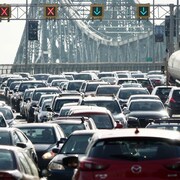 Plusieurs véhicules sont pris dans la congestion routière du pont Jacques-Cartier, à l'heure de pointe matinale à Montréal, alors qu'on voit les feux de circulation signalant les voies ouvertes et fermées dans les deux sens.