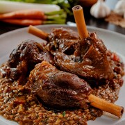 Des jarrets d'agneau braisés servis sur un lit de risotto d'épeautre.