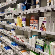 Des étagères de médicaments dans une pharmacie.