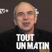 Julien Poulin sourit et tient un trophée. 