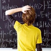 Un enfant devant un tableau noir couvert d'équations.