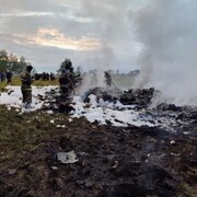 Des pompiers au milieu des débris après le crash d'un avion privé dans la région de Tver, en Russie, le 23 août 2023.