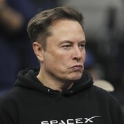 Portrait cadré d'Elon Musk qui regarde au loin.