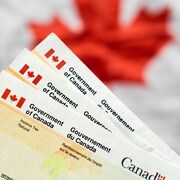Des documents de remboursement de l'impôt sur le revenu devant un drapeau canadien.