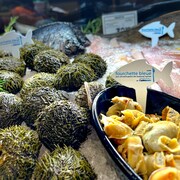 Étalage de fruits de mer à l'épicerie avec le logo Fourchette bleue en évidence.