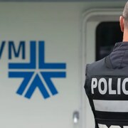Un policier, de dos, devant un logo du SPVM.