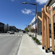 Des planches de bois sont plantées sur le trottoir de la 3e Avenue à Val-d'Or.