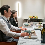 Deux hommes et deux femmes sont assis à table pour un repas.