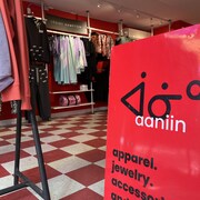 Une pancarte rouge dans une boutique de vêtements.