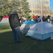 Des tentes et des manifestants occupent un terrain de l'Université de l'Alberta. À l'avant-plan, une banderole indique, en anglais: «bienvenue à l'Université du peuple pour la Palestine», à Edmonton, le jeudi 9 mai 2024.