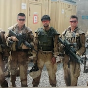 Abdul Hakim Azizi et quatre soldats canadiens, dont Tyson Martin, prennent la pose en uniforme militaire.