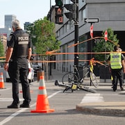 Deux vélos à terre dans une intersection entourés de policiers