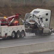 Un camion complètement embouti à l'avant se fait remorquer sur l'autoroute 401 à Whitby le 30 avril 2024.