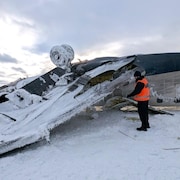 Un enquêteur tout proche de l'aéronef retourné et glacé.